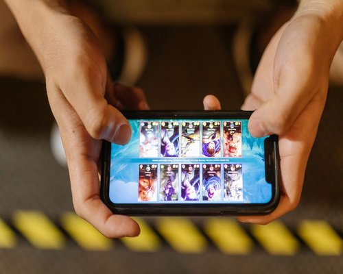 Smartphone displaying a fictional game during a DungeonCrownHeroes Australian gaming technology exhibition